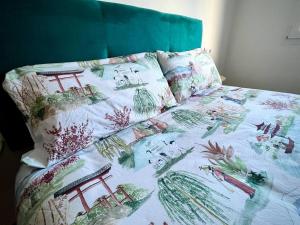 un letto con trapunta e cuscini colorati. di Ático en el centro recién reformado a Oviedo