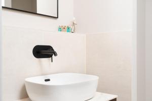 La salle de bains est pourvue d'un lavabo blanc et d'un miroir. dans l'établissement TSA La Rambla, à Barcelone