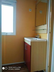 a small kitchen with a sink and a window at Mobil home au bord du lac in Nages +7 photos