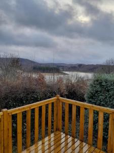 una terraza de madera con vistas a una masa de agua en Mobil home au bord du lac en Nages