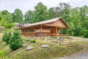 una baita di tronchi nel bosco con una recinzione di 4 Bed 3 Bath Vacation home in Bryson City a Bryson City