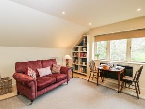 a living room with a red couch and a table at The Wool Barn in Warminster