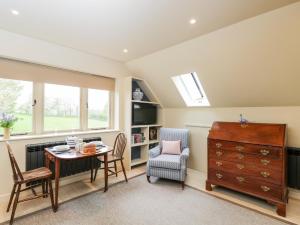 a living room with a table and chairs and a window at The Wool Barn in Warminster