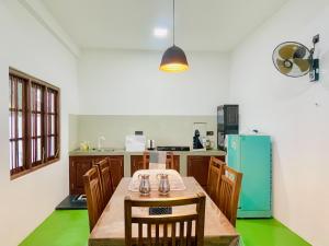 FARONA Beach Villa في أمبارا: مطبخ مع طاولة وكراسي وثلاجة