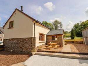 a cottage with a picnic table in the courtyard at Bunts Barn in Okehampton