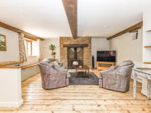 a living room with two chairs and a fireplace at Bunts Barn in Okehampton