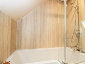bagno con doccia e vasca bianca di The Wool Barn a Warminster