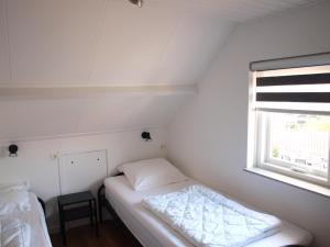 een kleine slaapkamer met een bed en een raam bij Appartement ,Vakantiewoning, Koddelaan 29 in Zoutelande
