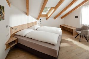 a bedroom with a bed with white pillows at Prälatenhof Wine & Apartments in Caldaro