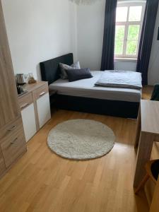 ein kleines Schlafzimmer mit einem Bett und einem Teppich in der Unterkunft Gasthaus Franz Inselkammer in Höhenkirchen-Siegertsbrunn