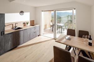 カルダーロにあるPrälatenhof Wine & Apartmentsのキッチン、ダイニングルーム(テーブル、バルコニー付)