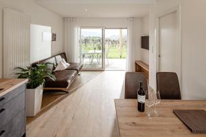 a living room with a couch and a table at Prälatenhof Wine & Apartments in Caldaro