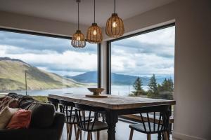 a dining room with a table and a large window at Ardlearag in Garve