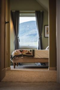a bedroom with a bed in front of a window at Ardlearag in Garve