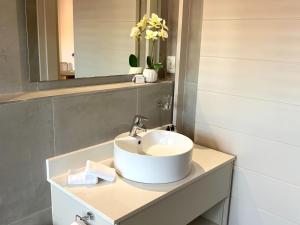 La salle de bains est pourvue d'un lavabo et d'un miroir. dans l'établissement Hermanus Waterfront Apartment, à Hermanus