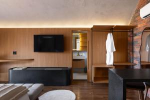 ein Wohnzimmer mit einem Sofa und einem TV an der Wand in der Unterkunft NÖR Hotel & SPA in São Roque