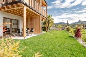a yard with a house with a grassy yard at Prälatenhof Wine & Apartments in Caldaro