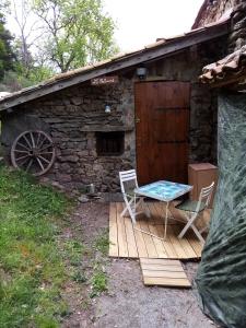 a table and chairs on a wooden deck in front of a cabin at La cabane in Palogneux