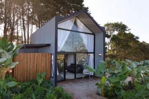 a small house with a large glass door at NÖR Hotel & SPA in São Roque