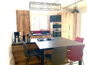 a kitchen with a table and some chairs in it at CAPUCINE Jolie maison proche Plage in La Couarde-sur-Mer