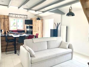 a living room with a couch and a kitchen at CAPUCINE Jolie maison proche Plage in La Couarde-sur-Mer