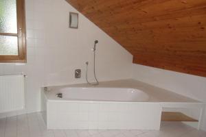 a white bath tub in a bathroom with a wooden ceiling at Seepanoramablick in Gmunden +17 photos