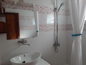 a white bathroom with a sink and a shower at Résidence Beyt Salama - T1bis ou T4 in Diego Suarez