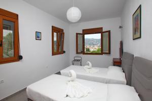 a room with three beds with swans on them at Finikas Apartments in Skopelos Town