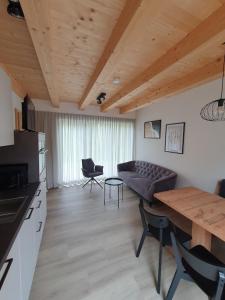 ein Wohnzimmer mit einem Sofa und einem Tisch in der Unterkunft Felsenfest Cottage in Kötschach