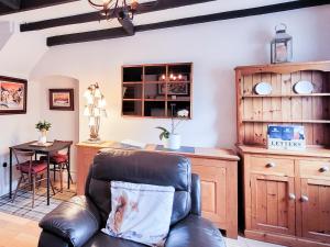 a living room with a leather chair and a table at The Nook in Bardon Mill