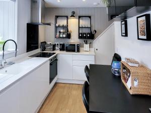 a kitchen with white cabinets and a black table at The Nook in Bardon Mill