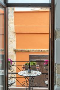 una mesa con 2 copas de vino en el balcón en Santa Elena Boutique Rooms, en La Canea