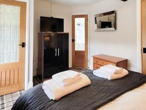 sypialnia z łóżkiem z dwoma ręcznikami w obiekcie The Nook w mieście Bardon Mill