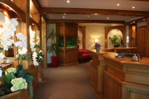 a large room with a waiting room with flowers at Au Relais de l'Ill in Sermersheim