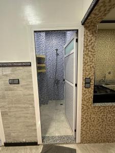 La salle de bains est pourvue d'une porte en verre menant à une douche. dans l'établissement Bel Appartement 1er Étage confortable près de la plage - spécialement pour familles, à Saïdia