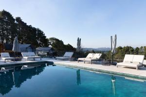 a swimming pool with white lounge chairs and a swimming pool at NÖR Hotel & SPA in São Roque