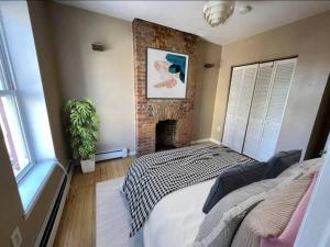 a bedroom with a brick fireplace and a bed at Liberty Dream - 20 min to NYC in Jersey City