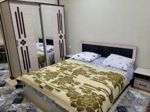 a bedroom with a bed and a large mirror at UZUMZOR HOUSE in Aktepa-Chigatay