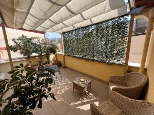 een balkon met stoelen en een tafel en planten bij Canale rooms e apartments in Casteldaccia