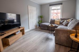 a living room with a couch and a flat screen tv at Cozy House with Modern Garden in Great Yarmouth