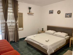 a bedroom with a bed and a red chair at 4 Studios Becic in Budva