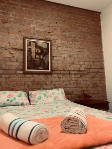 Ce lit se trouve dans une chambre dotée d'un mur en briques. dans l'établissement Kambô hostel, à São Paulo