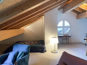 een slaapkamer met een loft met een bed en een tafel bij 4 1/2 Room Maisonette Apartment with great views in Sils Maria