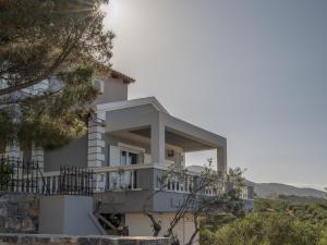 une maison blanche sur une colline avec des arbres dans l'établissement Carmine Olive Villa, à Agia Pelagia