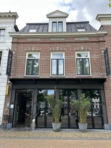 a brick building with glass doors on a street at Tres Boutique Hotel in Gorinchem