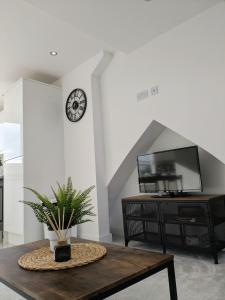 a living room with a table and a clock on the wall at Cardiff apartment in Cardiff