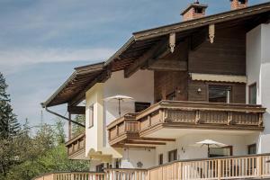 a large house with a balcony with umbrellas on it at Apart. Mountainlovers in Hainzenberg