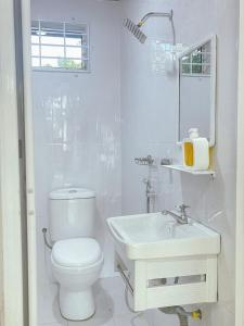 uma casa de banho branca com um WC e um lavatório em Kota Bharu RS Desa Roomstay em Kampong Haji Musa