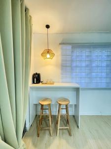 a kitchen with a table and two stools at Kota Bharu RS Desa Roomstay in Kampong Haji Musa