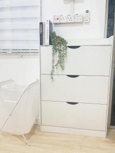 a white dresser with a plant on top of it at Kota Bharu RS Desa Roomstay in Kampong Haji Musa